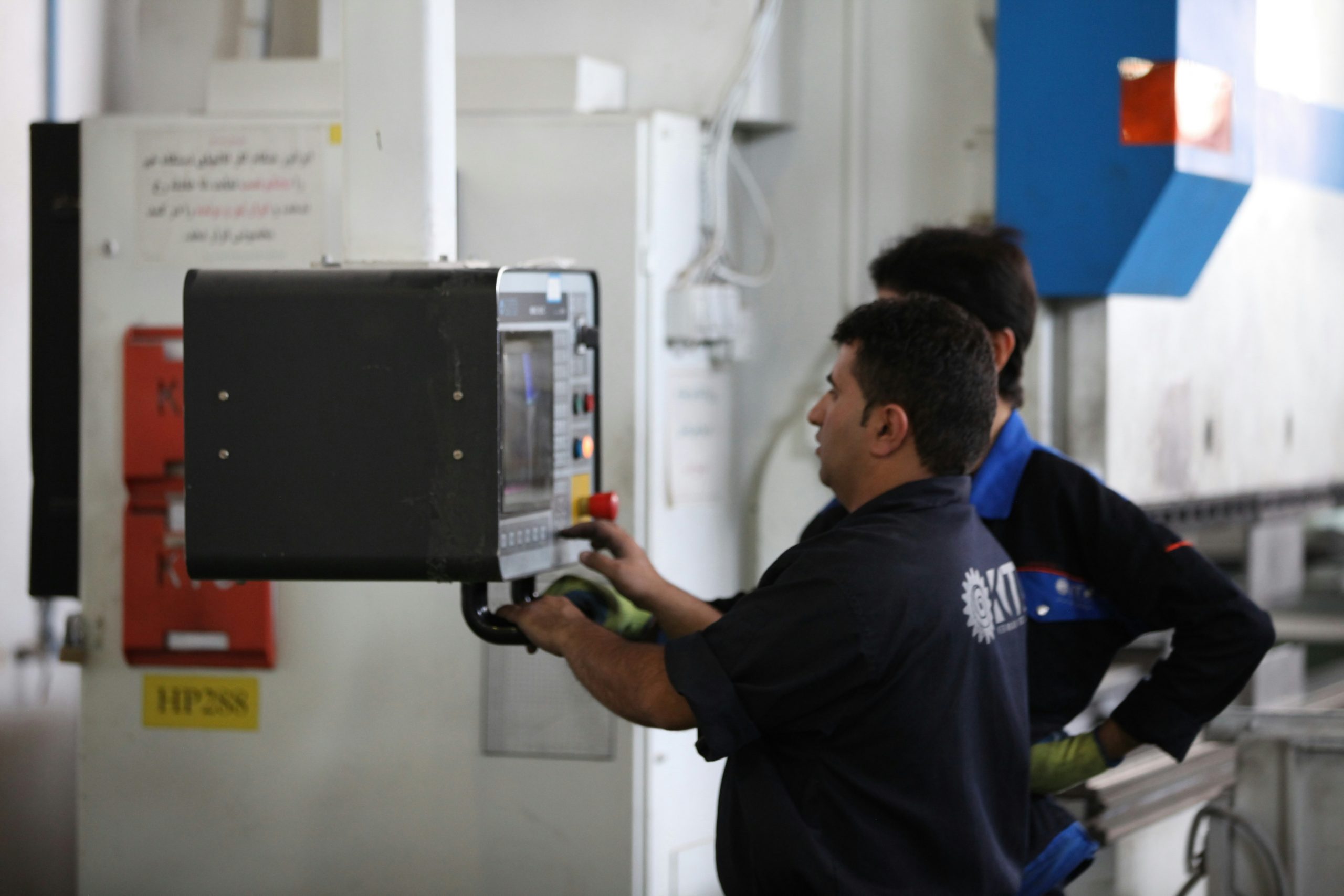 Team of two technicians checking their schedule on a smartphone in front of a branded utility van