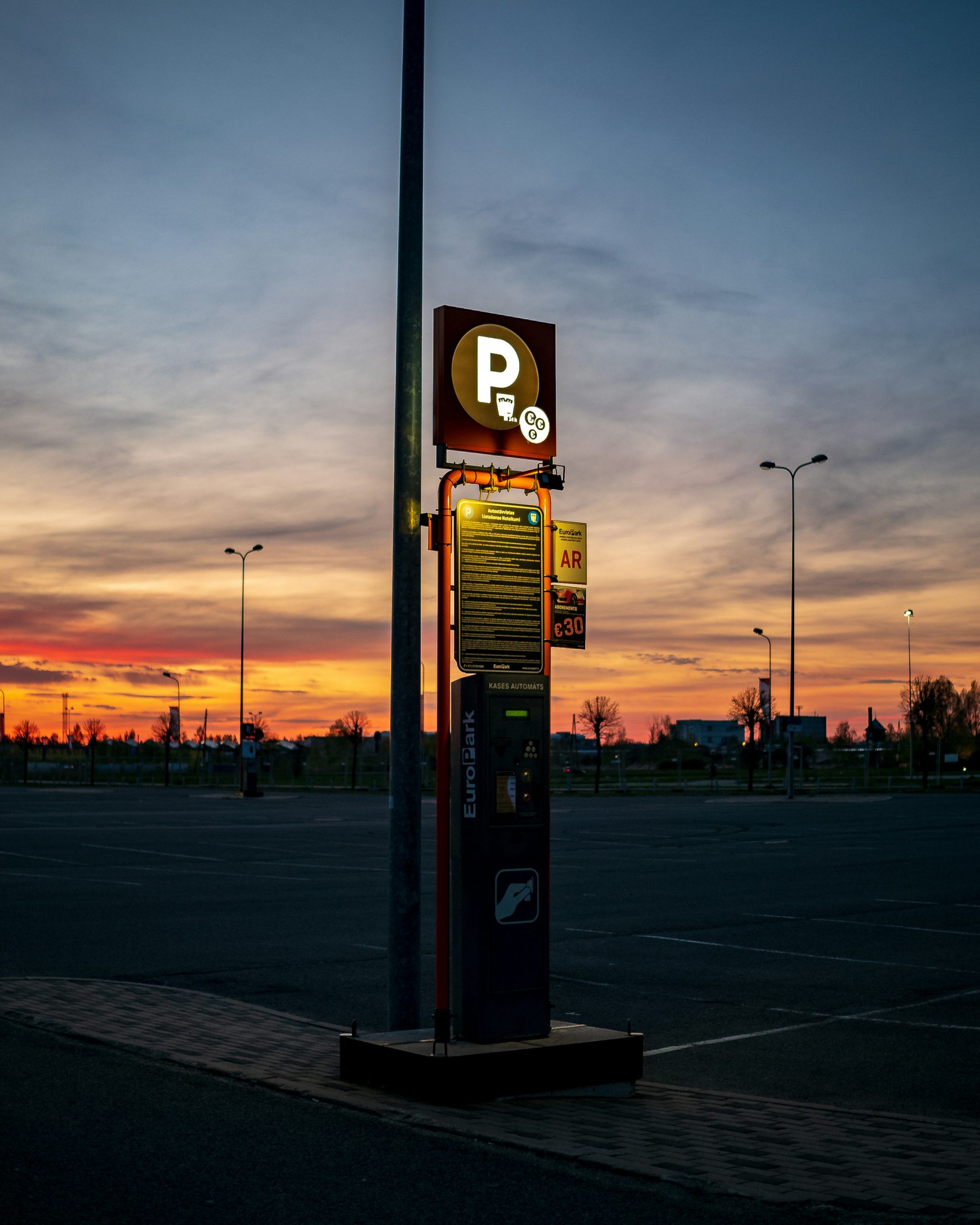 Modern electric vehicle charging station with green lights interface at sunset