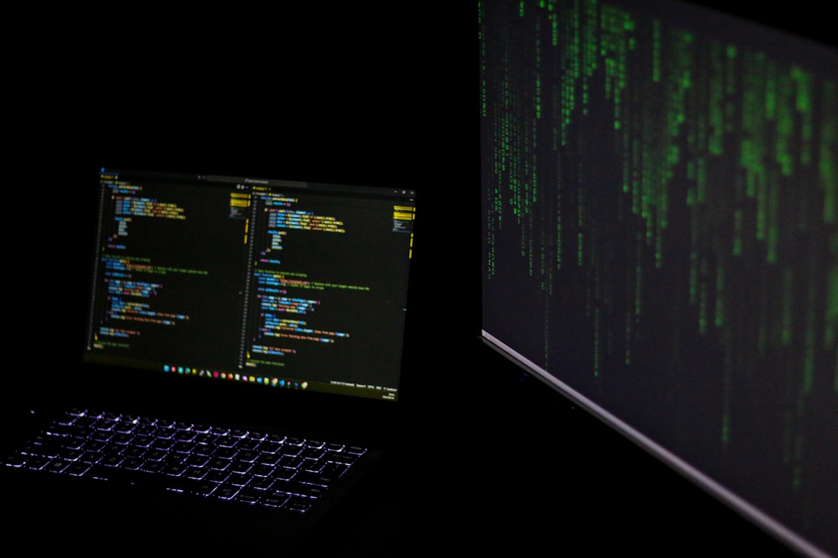 Écran d'ordinateur affichant du code informatique et un écran vert numérique.