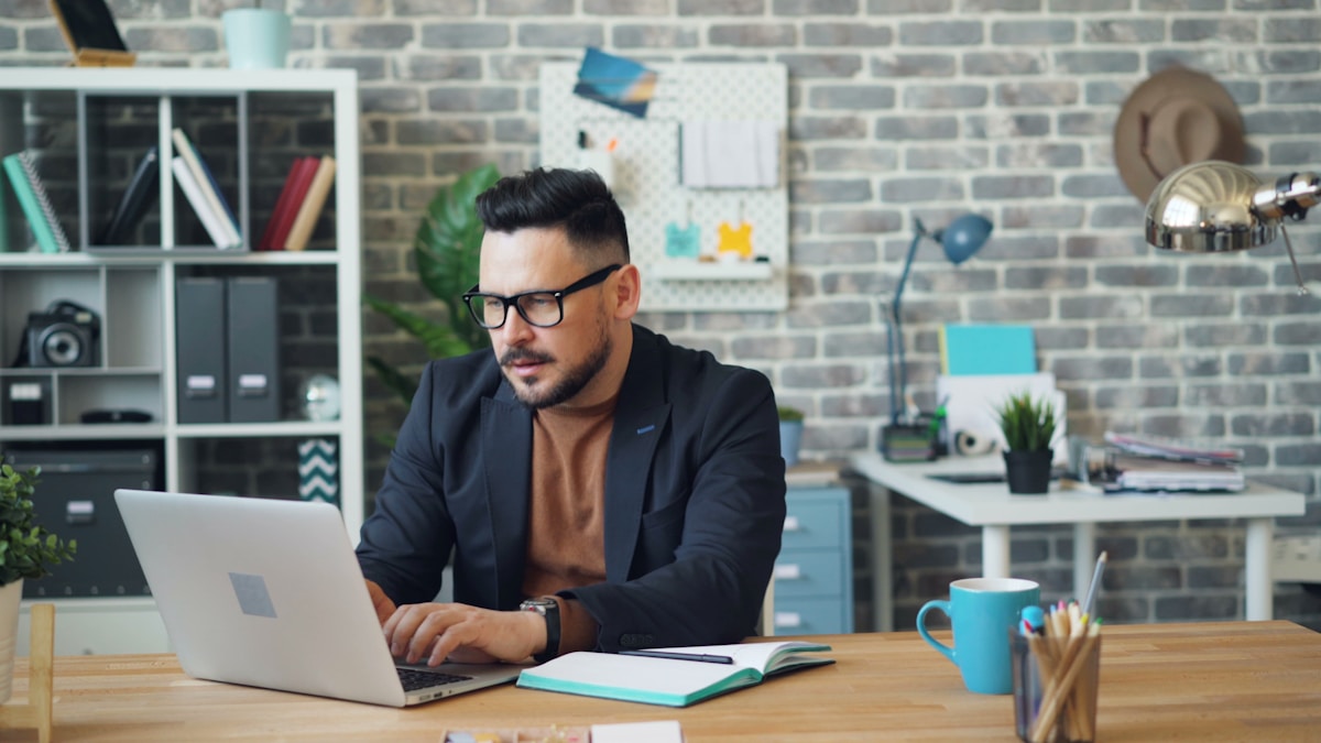 Homme d'affaires travaillant sur un ordinateur portable dans un bureau moderne.
