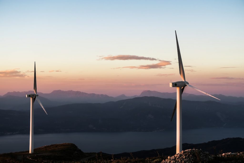 "Deux éoliennes blanches illustrant le futur de la gestion des primes énergie renouvelable"