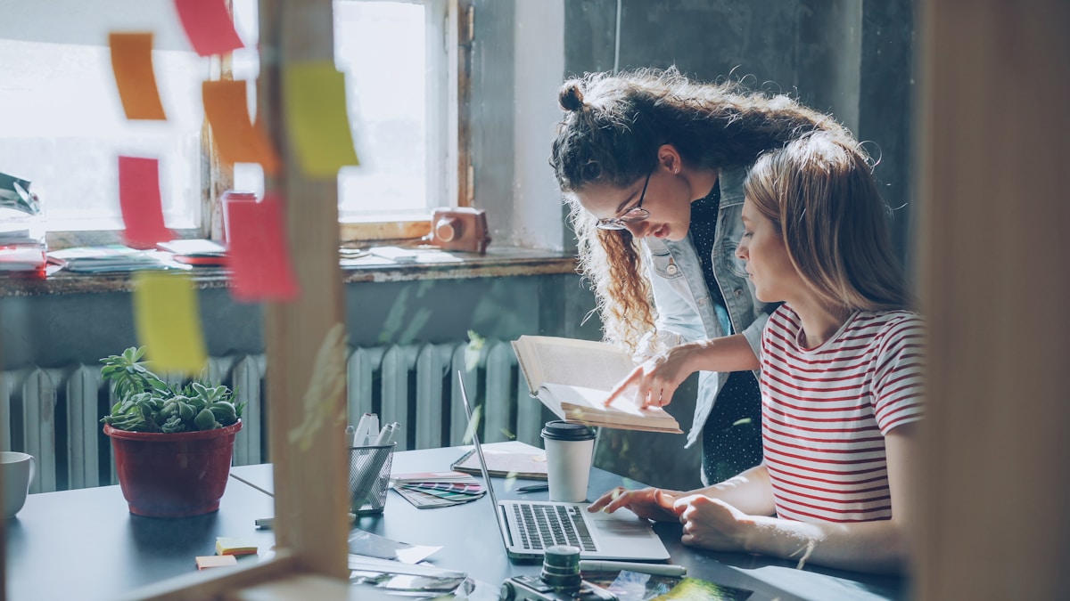 Deux jeunes femmes travaillant ensemble dans un espace de bureau créatif.