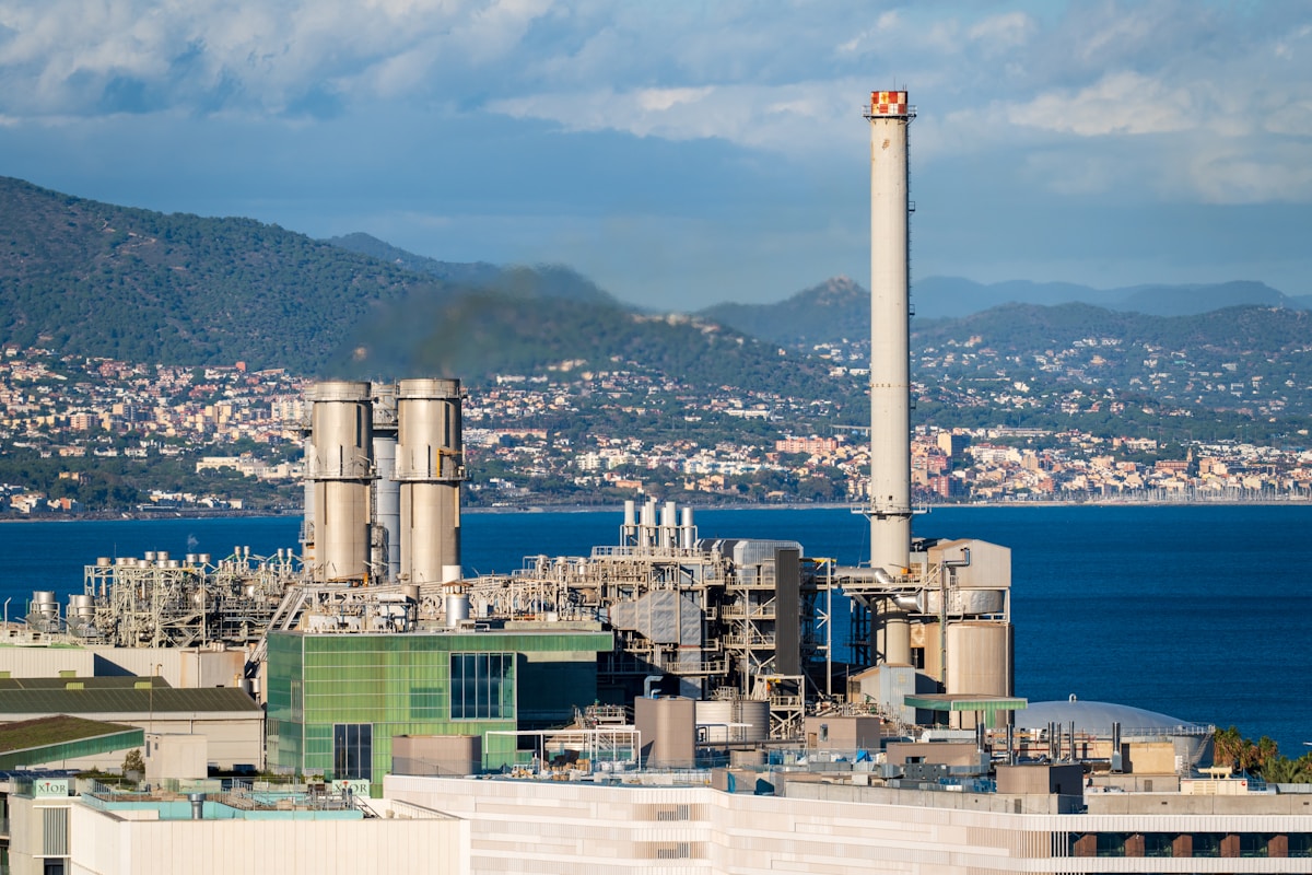 Centrale électrique côtière avec cheminée et vue sur la ville.