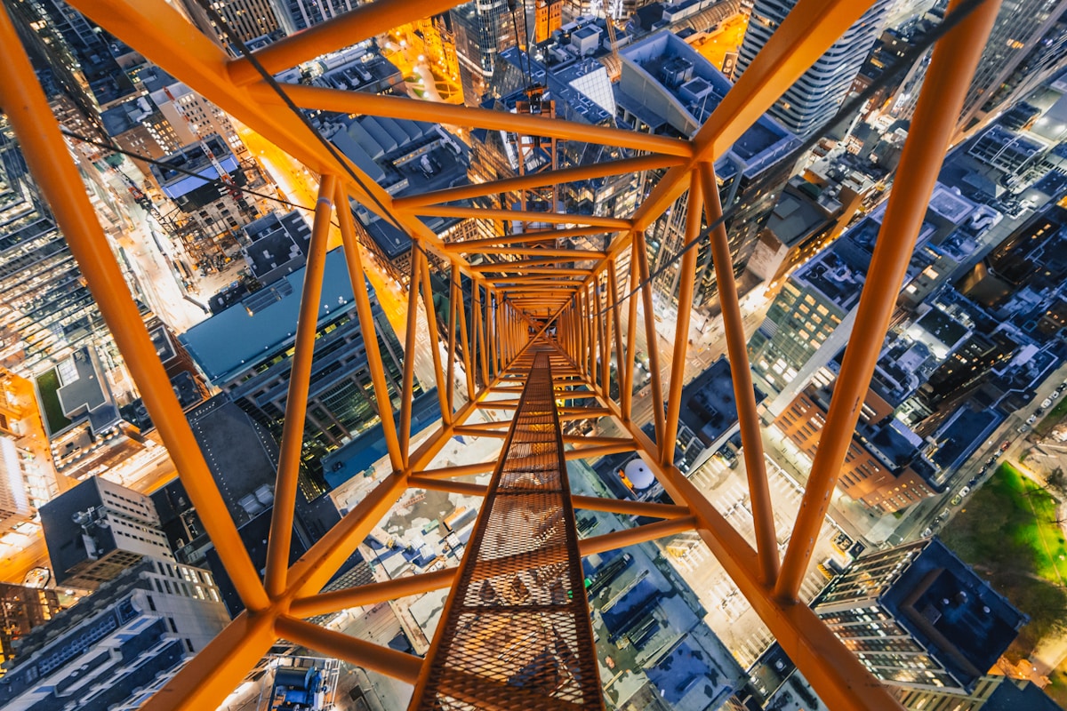 Structure métallique orange surplombant une ville.