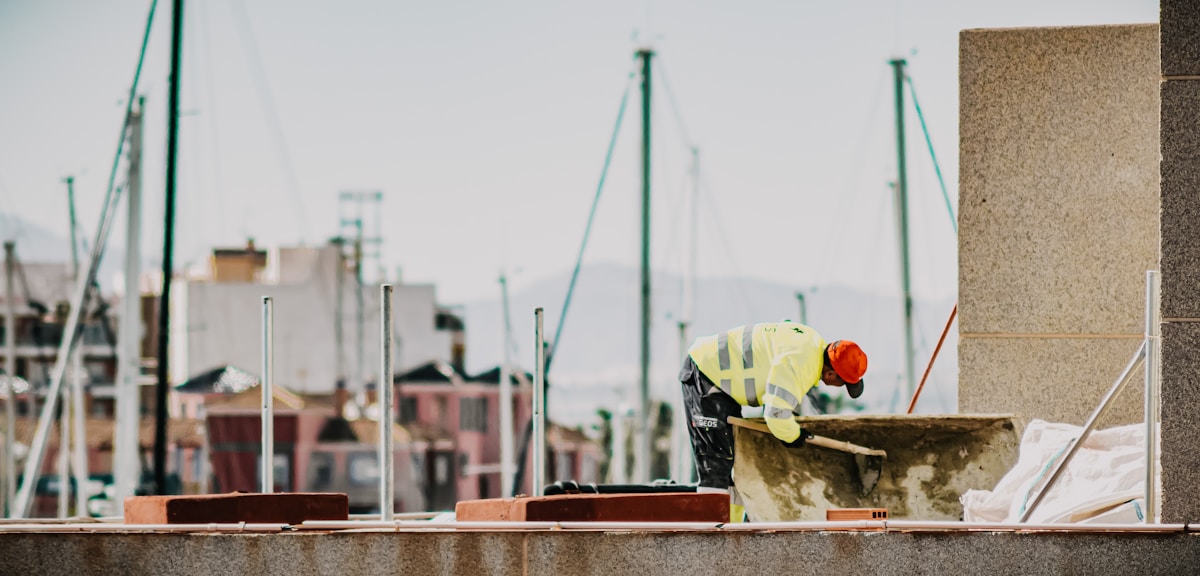 Chantier de construction avec ouvrier en équipement de sécurité.