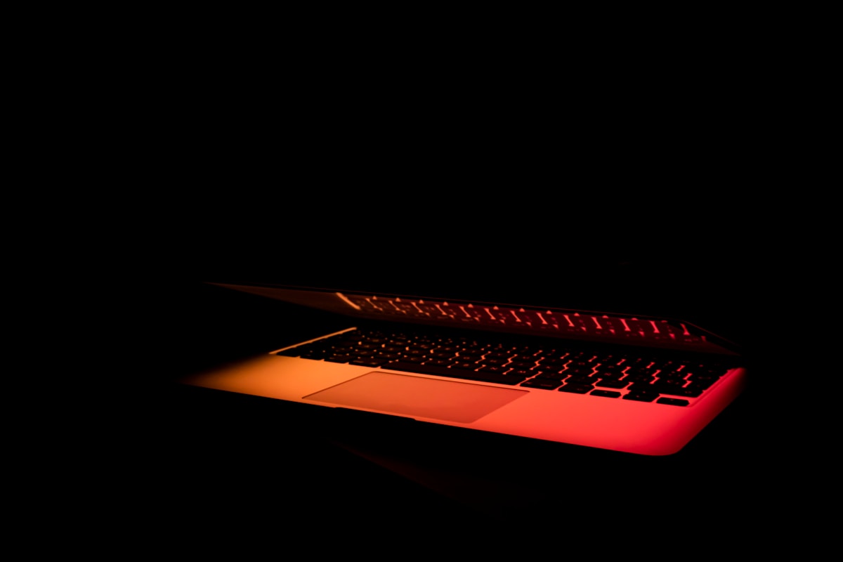 Clavier d'ordinateur portable rougeoyant dans l'obscurité.